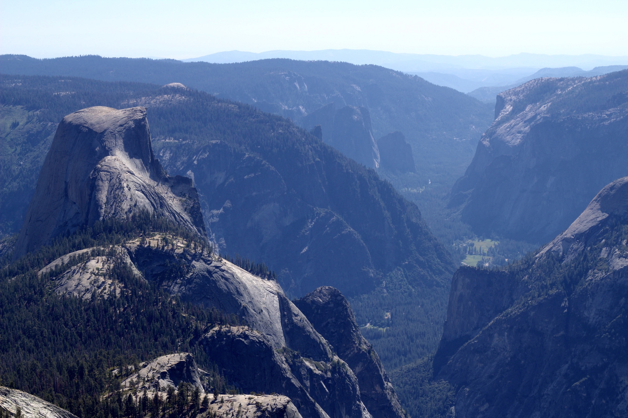Wide view across Yosemite Valley with Half Dome and distant mountains